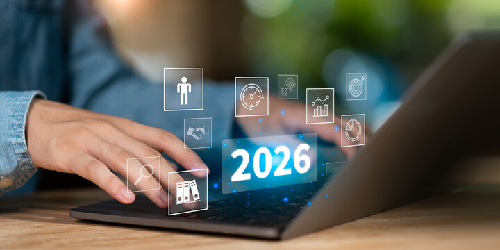 Hands typing on laptop with glowing 2026 and futuristic icons, representing digital planning, business goals, innovation, smart solutions, performance tracking, and strategic growth for the future.