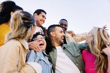 Group of multiracial millennial friends enjoying free time at the city street. Young community...