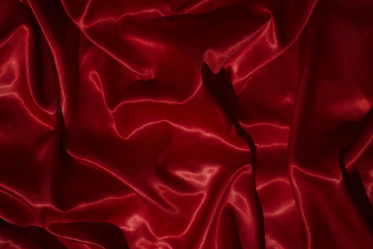 top view close-up of red satin fabric, smooth and luxurious, beautiful, classy, ​​wavy texture