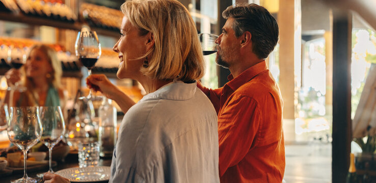 Group of friends enjoying a wine tasting at a boutique wine shop, sitting around a table with glasses
