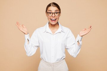 Young shocked excited happy surprised successful employee business woman corporate lawyer in classic formal white shirt work in office spread hands isolated on plain beige background studio portrait