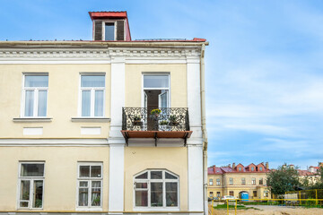 Obraz premium Old Yellow Building with Decorative Balcony and Blue Sky