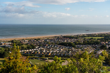 Elevated view across the town of Abergele towards the Irish Sea showing residential streets, sandy beach, and offshore wind turbines © Philip