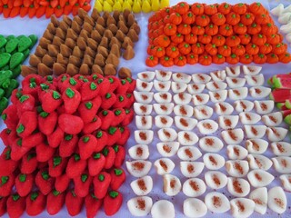 traditional mexican handmade colorful sugar sweets called muertitos in a form of fruit in a market of day of the dead, Mexico