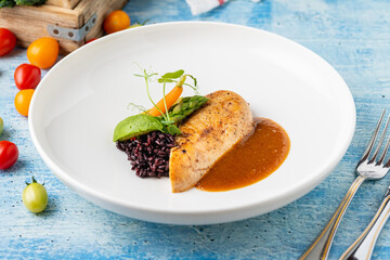 Grilled chicken fillet with black rice and vegetables in sauce