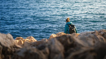 woman watching the sea with rocks