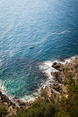 boat on blue sea from above on cliff with waves