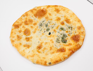 Georgian Khachapuri Pkhlovana With Herbs and Melted Cheese On White Surface