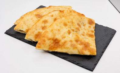 Georgian Khachapuri Pkhlovana With Herbs and Melted Cheese On White Surface