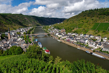 Panoramic view of the charming town along the Moselle River and its steep, terraced vineyards under a cloudy sky in Cochem, Germany