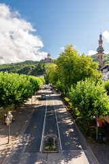 Cochem, Germany - September 9, 2025: View of the tree-lined Moselle promenade road in Cochem, Germany, with the historic Reichsburg Cochem castle visible on the hill in the background