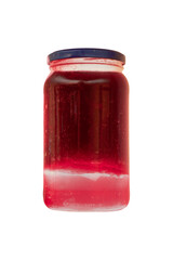 Glass jar with preserved cherry jam illuminated by backlight is isolated.