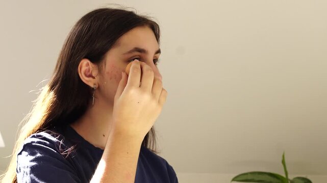 Teenager girl masking akne looking at the mirror