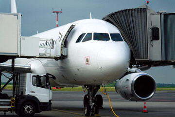 Charter airline airplane preparing for flight on airport runway with connected jet boarding bridge