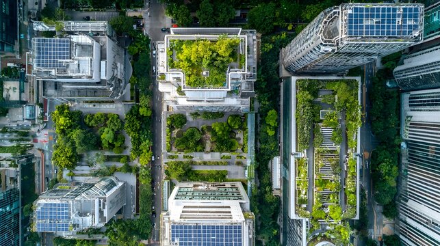 Overhead view captures modern city buildings featuring extensive rooftop gardens and solar panels