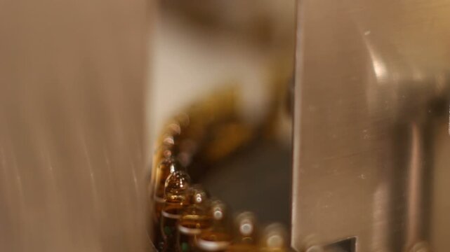 High-definition footage of an automated cleanroom assembly where glass ampoules are washed, filled with injectable medication, sterilized, and hermetically sealed. Showcases precision robotics, strict