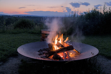 round circle fire pit burning logs at sunset in catskills mountains catskill upstate new york travel camping leisure scenic nature landscape flame wood wooden log warmth cozy outdoor adventure