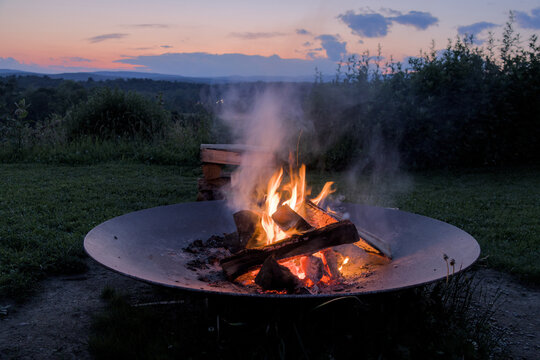 round circle fire pit burning logs at sunset in catskills mountains catskill upstate new york travel camping leisure scenic nature landscape flame wood wooden log warmth cozy outdoor adventure