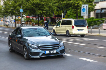 Grey sedan driving on city street with traffic. Dynamic commute.