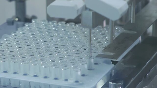High-definition footage of an automated cleanroom assembly where glass ampoules are washed, filled with injectable medication, sterilized, and hermetically sealed. Showcases precision robotics, strict