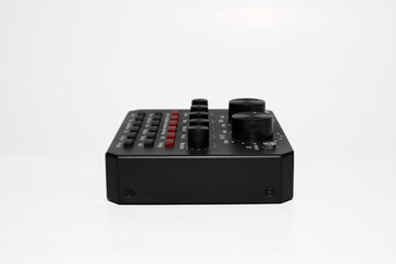 Compact, black audio interface with multiple buttons, knobs, input, and output ports isolated on white background. It's audio sound card for music equipment and recording, easy to use.