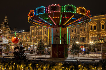 The illuminated Christmas carousel rotates, rolling people. Entertainment during the holidays....