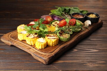 Vegetarian barbeque. Tasty grilled vegetables served on wooden table, closeup