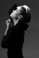 Black and white profile of a stylish woman posing with hand in hair, elegant and serene mood,...