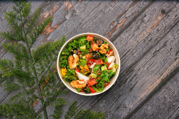 Fresh Quinoa Power salad with isolated wooden background. Breakfast power plate for healthy eating top view. Green healthy salad power plate eating. Vagan power bowl salad.