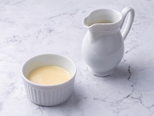 Condensed milk in a bowl over marble table