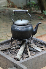 An old vintage kettle on a charcoal stove