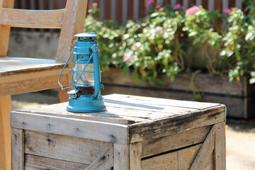 A blue old vintage lamp on a old wooden crate