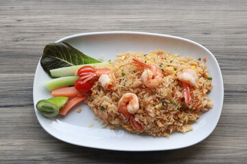 A plate of delicious fried rice with shrimp, beautifully presented with fresh vegetables 