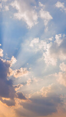 Sunlight rays shining through clouds in blue sky