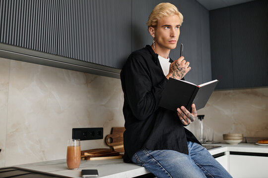 Young man reflects in a modern apartment while enjoying a quiet moment of inspiration