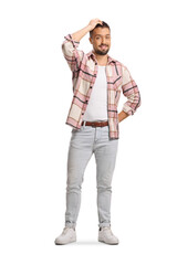 Fototapeta premium Full length portrait of a guy in checkered shirt holding his head and smiling