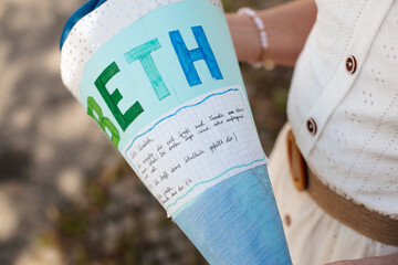 Personalized German Schultüte decorated with blue paper and handwritten note, celebrating a child’s first school day.