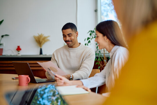 Professionals working together, reviewing documents and discussing during a productive meeting in a modern office environment