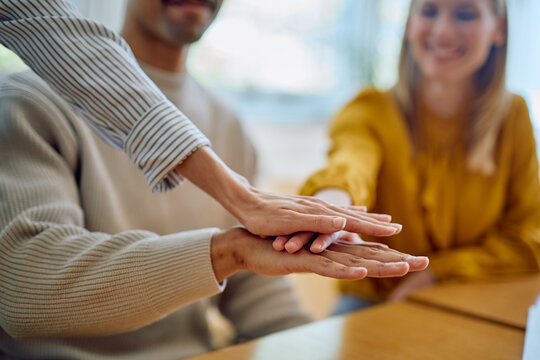 Business team stacking hands together, showing collaboration, support, and friendship. Office members celebrating success