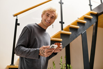 Young handsome man enjoying a moment in a stylish apartment with a cheerful smile