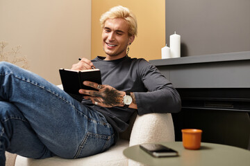 Young man enjoying creativity and comfort while writing in his cozy apartment