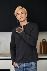 Handsome young man in modern apartment showcasing charm and style during afternoon moment