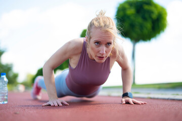 Woman doing push-ups exercising outdoors for fitness