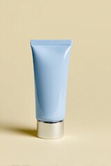 Pale blue cosmetic tube with silver base rests on a smooth, light background