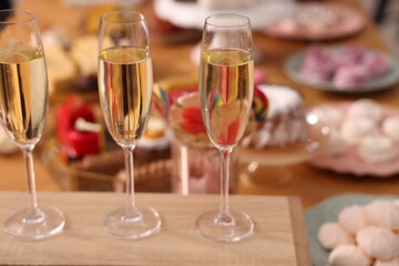Buffet menu. Glasses of sparkling wine and desserts on table, selective focus