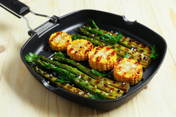 Delicious grilled vegetables with spices in pan on wooden table, closeup