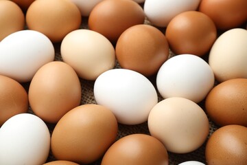 Many raw chicken eggs on table, closeup