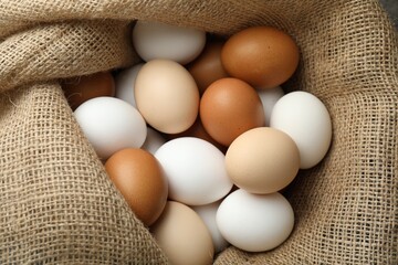Many raw chicken eggs in sack, closeup