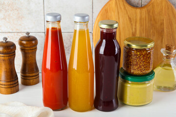 Different tasty sauces on white wooden table