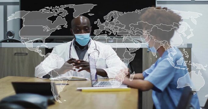 Doctor and nurse reviewing laptop in hospital meeting room, with notebook, pen and stethoscope